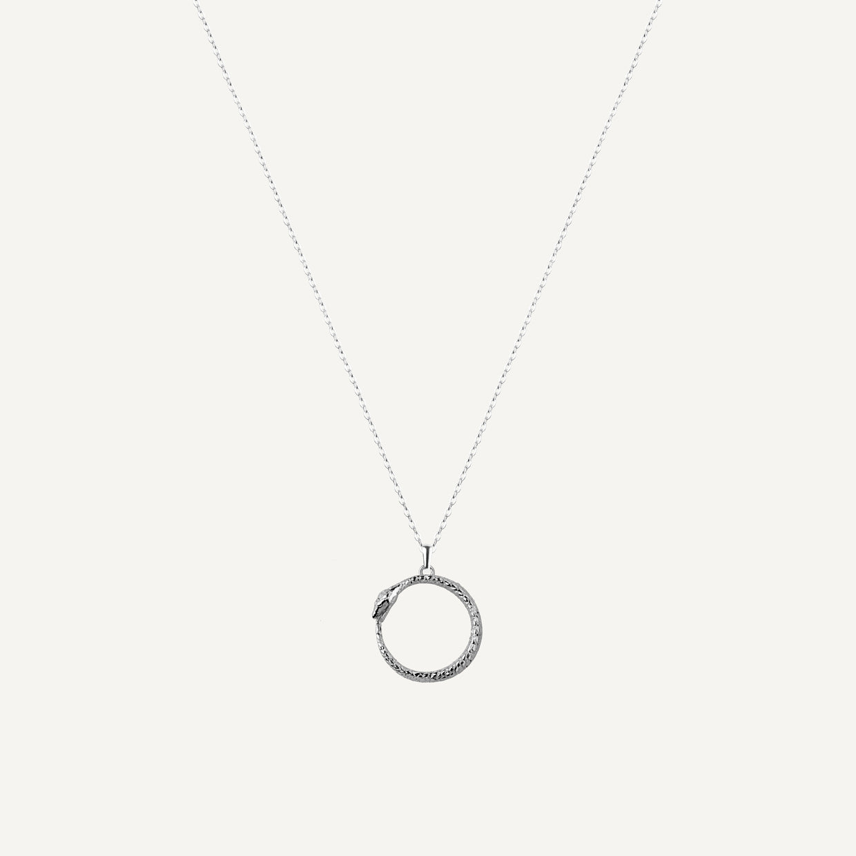 Collar Uroboros Silver es una pieza realizada a mano con métodos de joyería tradicional en latón, chapada en plata 925 con una capa protectora que extiende la durabilidad del chapado.