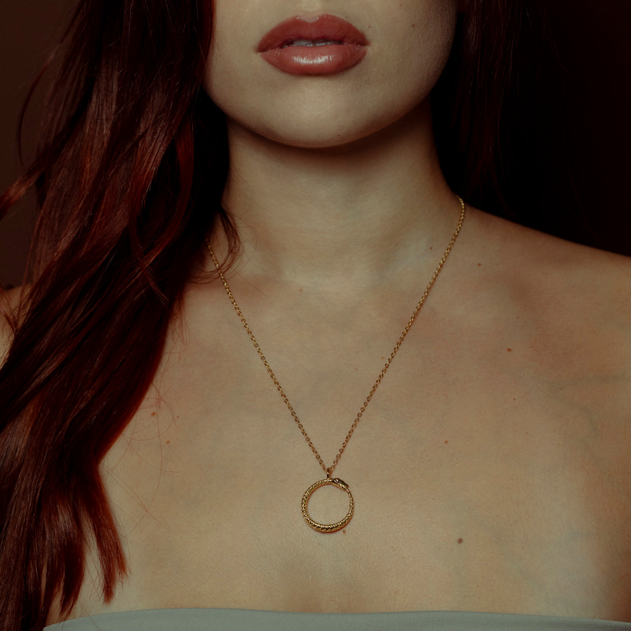 Collar Uroboros Gold es una pieza realizada a mano con métodos de joyería tradicional en latón, chapada en oro de 24k con una capa protectora que extiende la durabilidad del chapado.