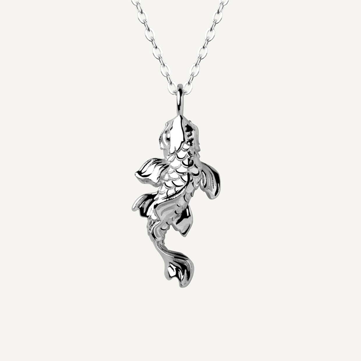 Collar Koi Silver es una pieza realizada a mano con métodos de joyería tradicional en latón, chapada en plata 925 con una capa protectora que extiende la durabilidad del chapado.